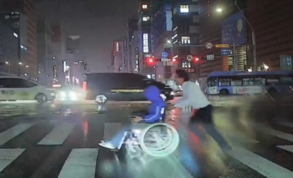 폭우 속에서 휠체어를 타고 힘겹게 횡단보도를 건너던 시민을 도운 버스 기사의 사연이 공개됐다. 사진은 지난 13일 버스 기사 이중호씨가 시민을 돕는 모습. /사진=서울시버스운송사업조합 영상 캡처