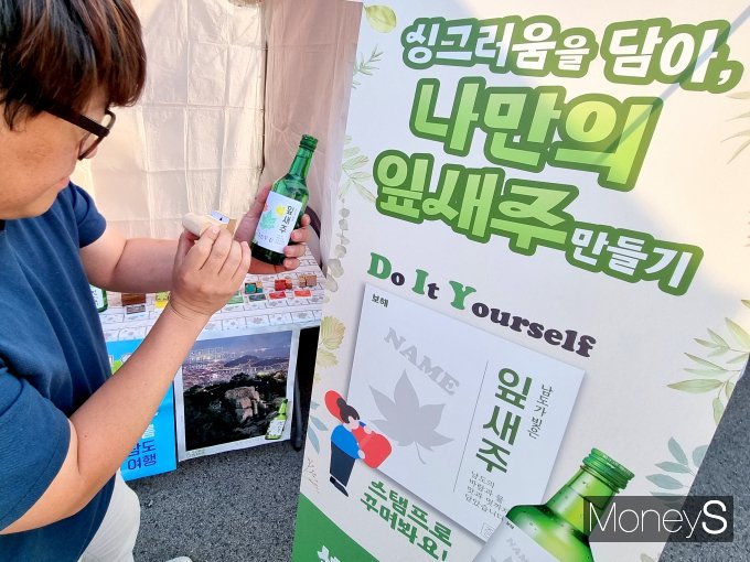 지난 29일까지 열린 국제남도음식문화큰잔치에서  한 관람객이 보해양조의 '나만의 잎새주' 만들기 이벤트에 참여하고 있다/사진=보해양조 제공.