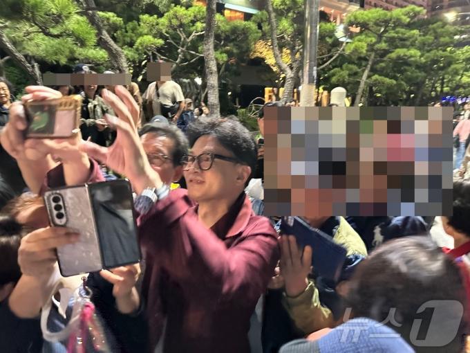 한동훈 국민의힘 대표가 5일 밤 부산 해운대해수욕장을 찾아 시민들과 만나 사진 촬영을 하고 있다. (독자 사진 제공)
