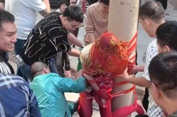 중국 전통 결혼 풍습인 '훈나오'가 최근 현지 네티즌들 사이에서 논란이다. 사진은 지난달 23일 신랑 측 친구들이 테이프로 신부를 전봇대에 매다는 모습. /사진=웨이보 캡처