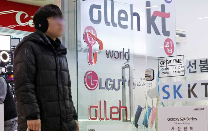 공정거래위원회가 이동통신 3사에 '판매장려금과 거래조건' 등을 담합했다는 혐의로 5조가 넘는 천문학적 과징금 부과를 검토하는 가운데 방송통신위원회는 담합이 아니라는 의견을 전해 이목이 끌린다. 사진은 지난 2월 서울의 한 휴대폰 매장 앞으로 시민이 지나가고 있는 모습. /사진=뉴스1