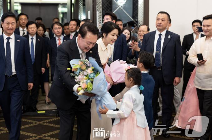 필리핀을 국빈 방문한 윤석열 대통령과 김건희 여사가 6일 오후(현지시간) 필리핀 마닐라 페닌슐라 호텔에서 열린 동포 만찬 간담회에 참석해 화동으로부터 꽃다발을 받고 있다. (대통령실 홈페이지) 2024.10.7/뉴스1 ⓒ News1 송원영 기자