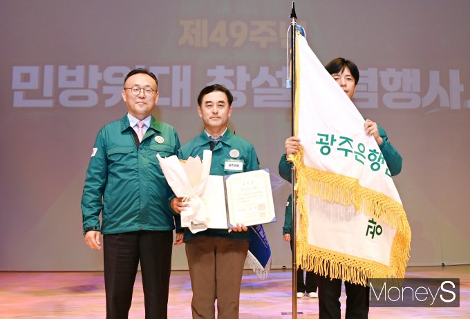 이한경 행정안전부 재난안전관리본부장(왼쪽)이 손희대 광주은행 안전관리부장(가운데)에게 '민방위 업무 유공' 국무총리 표창을 전달하고 있다/사진=광주은행 제공. 