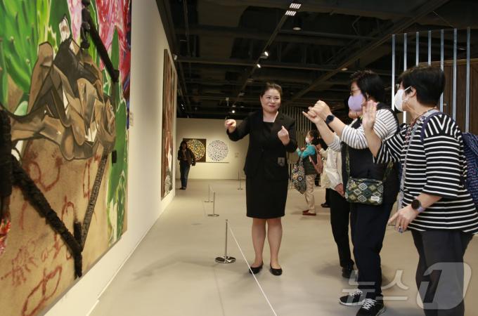 세화미술관에서 열리고 있는 제임스 로젠퀴스트의 개인전에서 도슨트가 수어로 설명하는 모습. 세화미술관 제공.