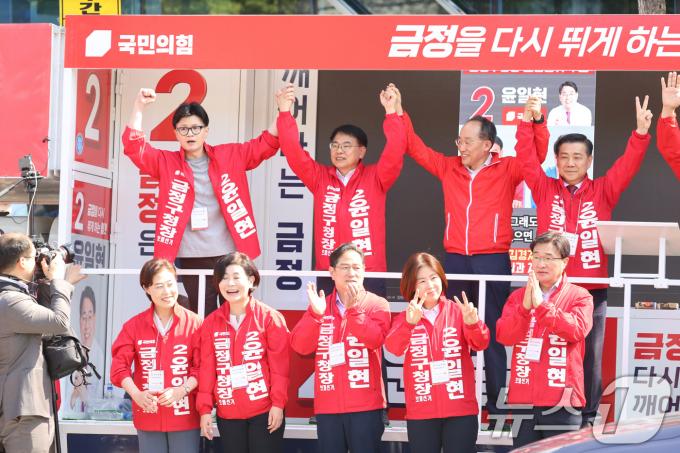 한동훈 국민의힘 대표가 12일 오전 부산 금정구 노포 오시게시장에서 열린 윤일현 금정구청장 후보 시장인사 및 집중유세에서 추경호 원내대표, 윤 후보와 손을 들어보이고 있다. (국민의힘 제공) 2024.10.12/뉴스1