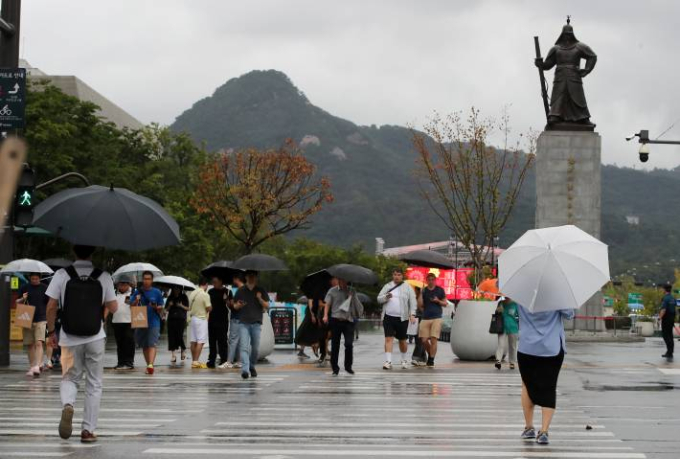 서울 세종대로사거리 횡단보도에서 우산을 쓴 시민들이 이동하고 있다./사진=뉴스1