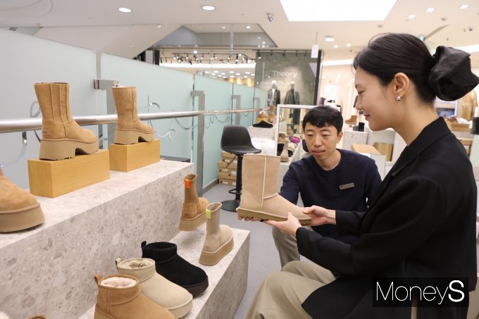 롯데백화점 광주점 '어그(UGG) 팝업 매장'을 찾은 여성 고객이 신발을 고르고 있다/사진=롯데백화점 홍보 3팀 제공.