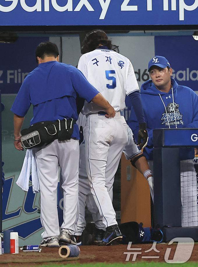15일 오후 대구 삼성라이온즈파크에서 열린 프로야구 '2024 신한 SOL 뱅크 KBO 포스트시즌' 플레이오프 2차전 LG 트윈스와 삼성 라이온즈의 경기, 삼성 구자욱이 1회말 2사 2루에서 디아즈의 적시 2루타 때 득점 후 팀 의료진의 부축을 받으며 더그아웃으로 향하고 있다. 2024.10.15/뉴스1 ⓒ News1 김진환 기자