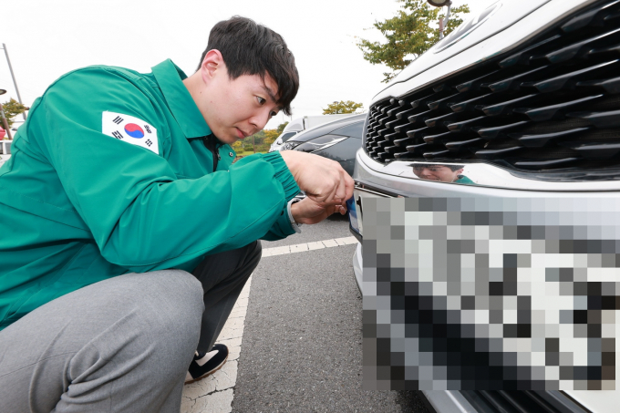 예천군 관계자가 한 체납차량의 번호판을 영치 중인 모습/사진제공=경북 예천군