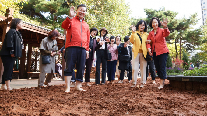 지난 24일 열린 내손어린이공원 맨발걷기길 개장식에서 김성제 의왕시장이 황톳길을 걸으며 즐거워하고 있다. 