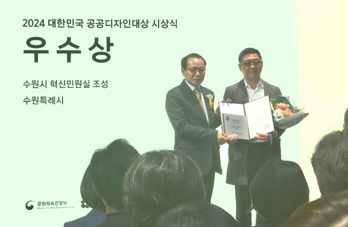  수원특례시 관계자가 한국공예·디자인문화진흥원 장동광 원장(왼쪽)으로부터 '2024 대한민국 공공디자인 대상'에서 우수상 수상 후 기념촬영을 하고 있다. / 사진제공=수원특례시