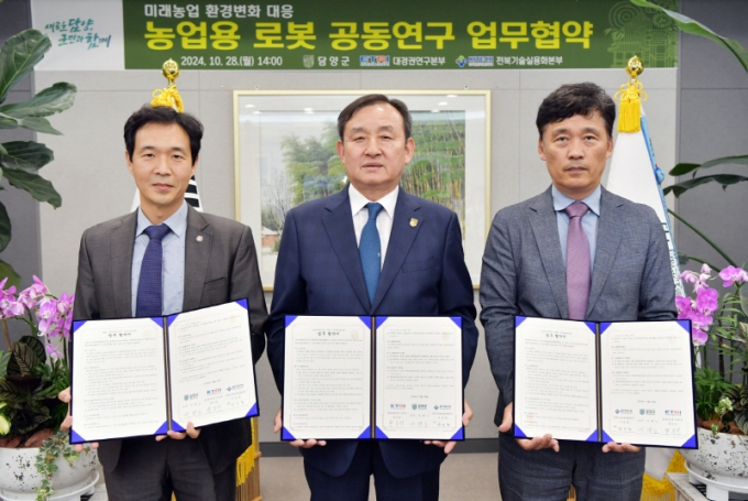 이병노 전남 담양군수(가운데)가 28일 한국전자통신연구원 대경권연구본부, 한국생산기술연구원 전북기술실용화본부와 농업용 로봇 및 스마트팜 공동연구를 위한 업무협약을 체결하고 있다./사진=담양군 