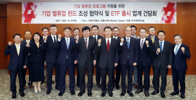 31일 서울 영등포구 한국거래소에서 열린 밸류업 ETF 발행사 대표 간담회에서 정은보 한국거래소 이사장(앞줄 왼쪽 여섯 번째)과 기업 밸류업 펀드 조성에 참여한 5개 유관기관 대표 및 코리아 밸류업 지수 ETF를 출시하는 12개 발행사 대표들이 파이팅을 외치며 기념촬영을 하고있다./사진=뉴스1 /사진=(서울=뉴스1)