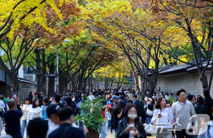 서울의 낮 최고기온이 24도 가까이 오르는 등 포근한 날씨를 보인 지난 3일 오후 서울 중구 덕수궁 돌담길에 단풍이 물든 가운데 외국인 관광객들이 늦가을 정취를 즐기고 있다. /뉴스1 ⓒ News1 김진환 기자