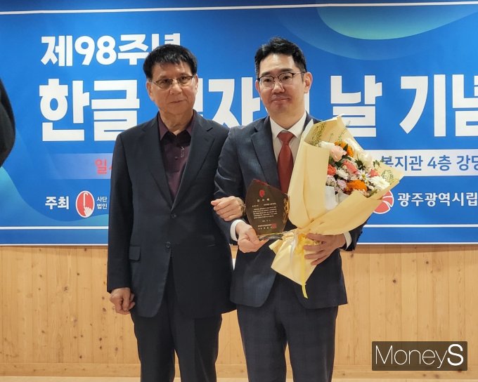 강태환 롯데아울렛 광주수완점 부점장(오른쪽)이 점자의날 기념식에서 유공 표창을 받은 후 광주시각장애인연합회장과 기념촬영을 하고 있다/사진=롯데백화점 홍보 3팀 제공.