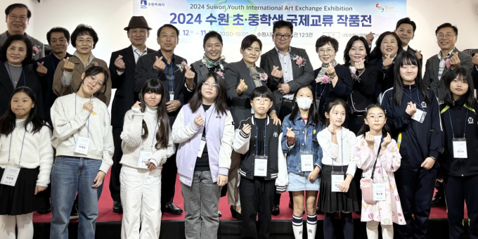 수원시국제교류센터가 주최하는 '2024 수원 초·중학생 국제교류 작품전' 첫 현장 전시 개막식에 참석한 관계자들이 기념촬영을 하고 있다.