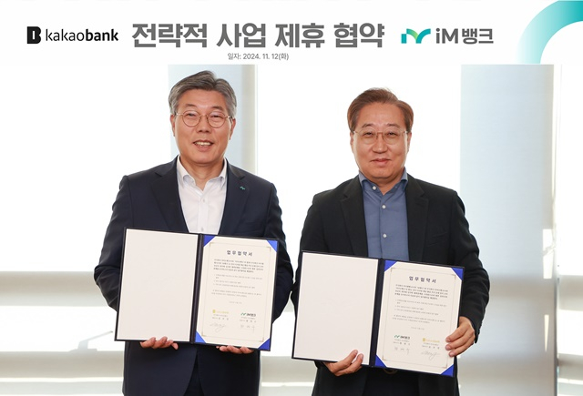 황병우 iM뱅크 은행장(왼쪽)과 윤호영 카카오뱅크 대표(오른쪽)가 협약서를 들어보이고 있다./사진제공=iM뱅크