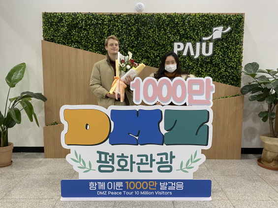  네덜란드인 옌스 올센 씨(왼쪽)와 한국인 박소영 씨(오른쪽)가 '파주 DMZ 평화관광' 1천만 번째 관광객으로 당첨돼 선물을 받고 기념촬영을 하고 있다.  /사진제공=파주시