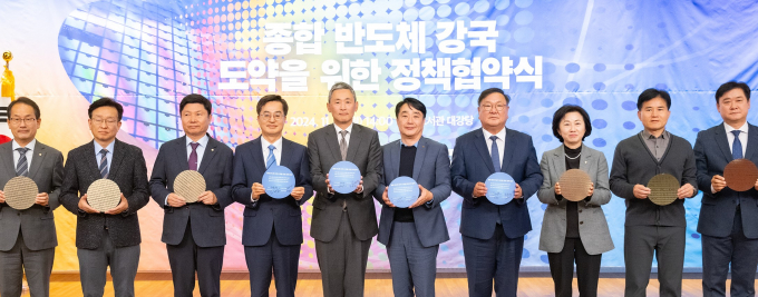18일 국회도서관 대강당에서 열린 종합 반도체 강국 도약을 위한 정책협약식에서 김동연경기도지사(왼쪽 네 번째) , 김태년 국회의원(왼쪽 일곱 번째), 김정회 한국반도체산업협회회장(왼쪽 다섯 번째), 김경수 한국팹리스산업협회장(왼쪽 여섯 번째) 등이 반도체 웨이퍼를 들고 기념촬영 하고 있다. 사진제공=경기도 