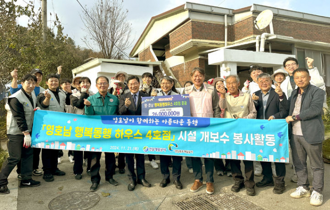 전남개발공사와 경북개발공사 관계자들이 21일 담양에서 영호남 행복동행 하우스 4호점 시설 개보수 봉사활동 후 기념사진을 찍고 있다./전남개발공사 
