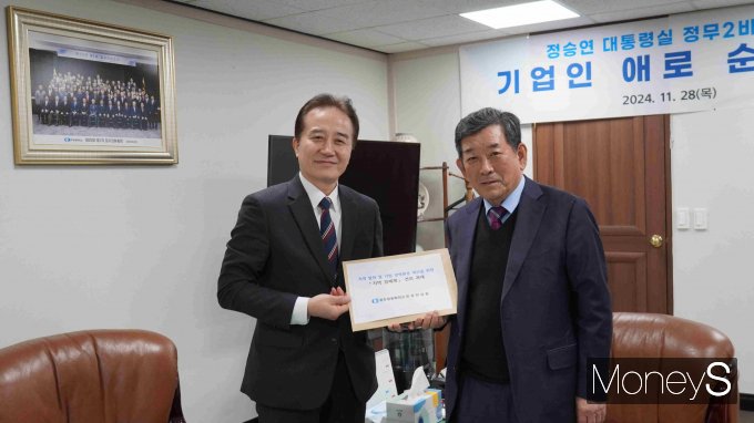 한상원 광주상공회의소 회장(오른쪽)이 정승연 정무2비서관에게  '지역 발전·기업경영환경 개선을 위한 지역 경제계 의견을 담은 건의문'을 전달하고 있다/사진=광주상의 제공.