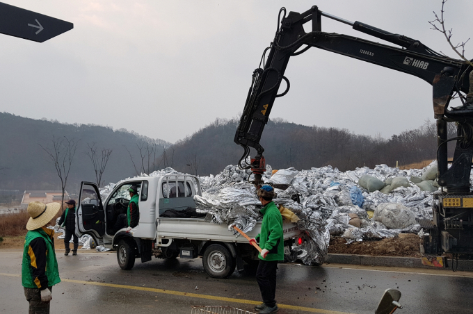 영주시 관계자들이 과수용 반사필름을 수거하고 있다./사진제공=경북 영주시