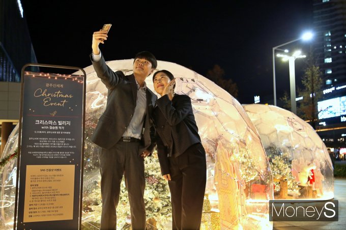광주신세계 야외광장에 설치된 크리스마스 빌리지에서 방문객들이 사진을 찍고 있다/사진=광주신세계 제공.