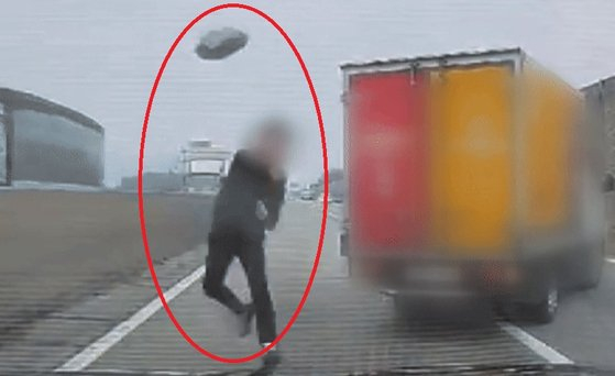 고속도로 주행 중 차를 세운 뒤 뒤에 오던 차량에 돌을 던진 40대 남성이 집행유예를 선고받았다. 사진은 뒤따르던 차량에 돌을 던지고 있는 A씨 모습. /사진=KBS 보도화면