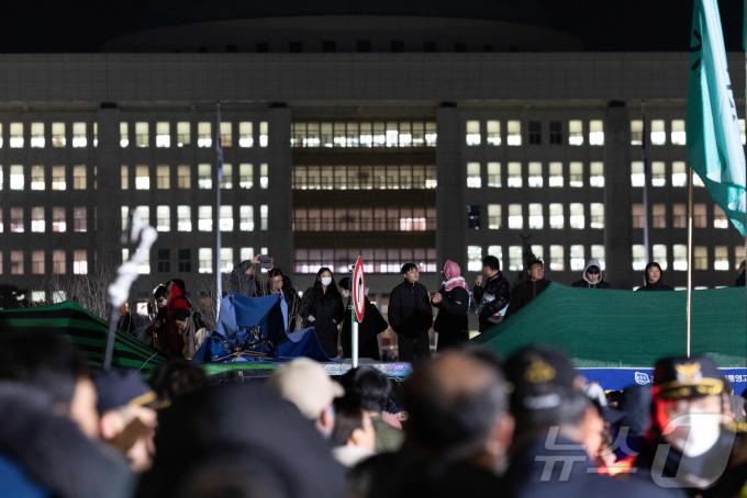 윤석열 대통령의 비상계엄 해제 요구 결의안이 국회 본회의에서 통과된 4일 새벽 서울 여의도 국회 정문 앞에 모인 시민들이 모여 있다. 여야는 이날 본회의에서 재석 190명 중 찬성 190명으로 비상계엄 해제 요구 결의안을 가결 처리했다. 이에 따라 계엄령 선포는 무효가 됐다고 국회의장실은 설명했다. 윤 대통령은 긴급 대국민 특별담화를 통해 