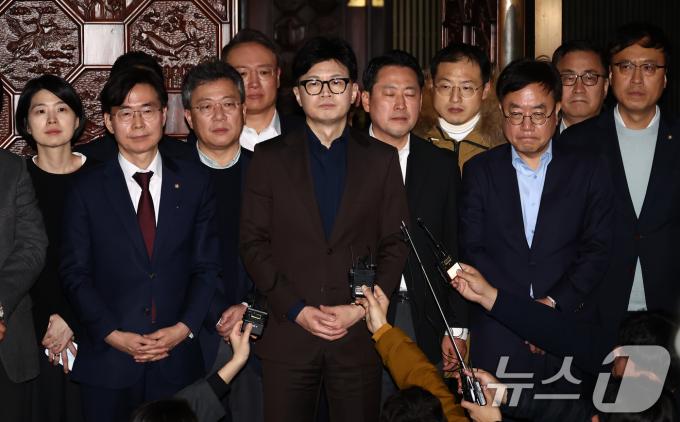 한동훈 국민의힘 대표를 비롯한 의원들이 4일 새벽 서울 여의도 국회 본회의장 앞에서 윤석열 대통령의 비상계엄 해제 대국민담화 관련 입장 발표를 하고 있다. 2024.12.4/뉴스1 ⓒ News1 김민지 기자