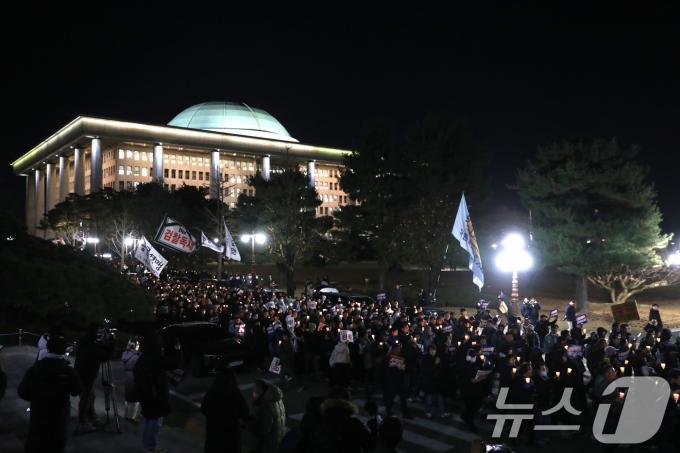 4일 오후 서울 여의도 국회 본청 앞 계단에서 열린 윤석열 대통령 사퇴촉구·탄핵 추진 범국민 촛불문화제를 마친 참가자들이 촛불을 들고 국회 경내를 행진하고 있다. 2024.12.4/뉴스1 ⓒ News1 이광호 기자