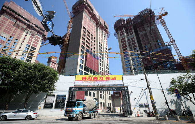 법무법인 율촌 건설클레임연구소가 늘어나는 건설업계 분쟁에 '공사계약 중도타절의 법적 문제'를 주제로 세미나를 개최했다. 사진은 지난 6월 서울 강남구 청담동 재건축 현장 입구에 공사 중지 예고 현수막이 붙어 있는 모습이며 기사와 직접 관련 없음. /사진=뉴스1