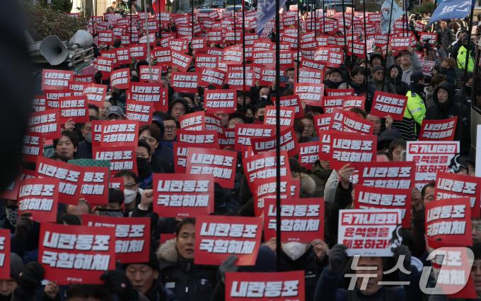 6일 서울 여의도 국회의사당 앞에서 열린 '내란범 윤석열 즉각 탄핵! 민심거역 국민의힘 규탄! 민주노총 결의대회'에서 참석자들이 손피켓을 들고 구호를 외치고 있다. 2024.12.6/뉴스1 ⓒ News1 이동해 기자