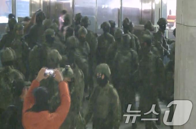 국회사무처가 계엄군의 국회 본관 진입 과정이 담긴 CCTV를 4일 공개했다. 김민기 국회사무총장은 국방부가 헬기로 24차례에 걸쳐 무장한 계엄군 230여 명을 국회 경내로 진입시켰다며 0시 40분에는 계엄군 50여 명을 추가로 국회 외곽 담장을 넘어 진입시켰다고 전했다. 사진은 국회 본관 진입을 시도하는 계엄군 모습. (국회사무처 제공) 2024.12.4/뉴스1