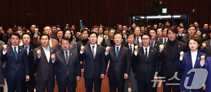 더불어민주당 이재명 대표를 비롯한 의원들이 9일 서울 여의도 국회에서 열린 의원총회를 마치고 태극기 배지를 달고 윤석열 대통령과 국민의힘을 규탄하는 구호를 외치고 있다. 2024.12.9/뉴스1 ⓒ News1 김민지 기자