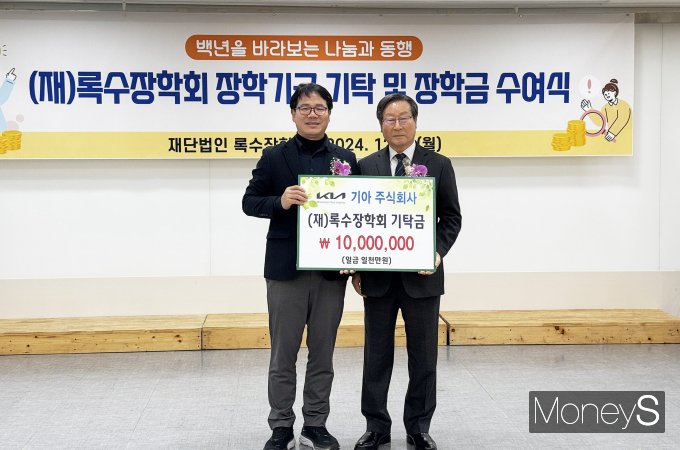 김승현 기아 AutoLand광주 안전시설담당 실장(왼쪽)이 김봉길 록수장학회장에게 소방공무원 자녀를 위한 후원금 1000만원을 전달하고 있다/사진=기아AutoLand광주 제공.