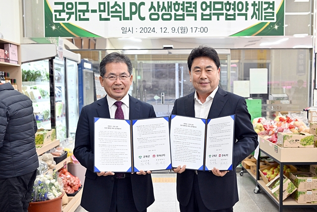 김진열 군위군수(왼쪽)이 권혁수 민속LPC(오른쪽)와 업무협약서를 들어보이고 있다./사진제공=대구 군위군