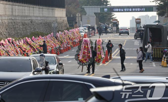 11일 오후 서울 용산구 대통령실 출입문 앞 도로에서 화환 업체 관계자가 윤석열 대통령 지지자들이 보낸 화환을 옮기고 있다. 2024.12.11/뉴스1 ⓒ News1 장수영 기자