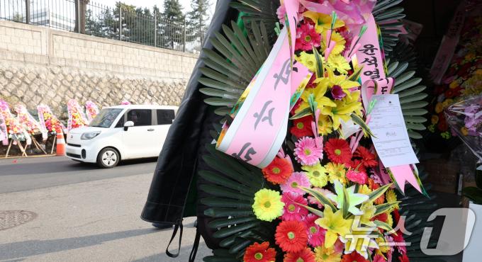 11일 오후 서울 용산구 대통령실 출입문 앞 도로에 윤석열 대통령 지지자들이 보낸 화환이 놓여져 있다. 2024.12.11/뉴스1 ⓒ News1 장수영 기자