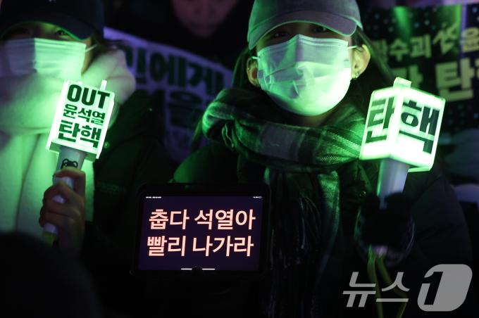 11일 오후 서울 영등포구 여의도 국회 앞에서 열린 '윤석열 즉각 탄핵 구속 촉구 촛불문화제'에서 참가자들이 응원봉과 손팻말을 들고 있다. 2024.12.11/뉴스1 ⓒ News1 김진환 기자