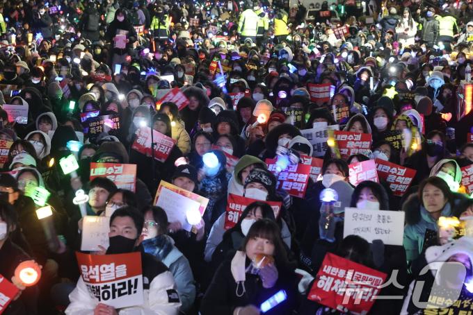 11일 오후 서울 영등포구 여의도 국회 앞에서 열린 '윤석열 즉각 탄핵 구속 촉구 촛불문화제'에서 참가자들이 응원봉과 손팻말을 들고 있다. 2024.12.11/뉴스1 ⓒ News1 김진환 기자
