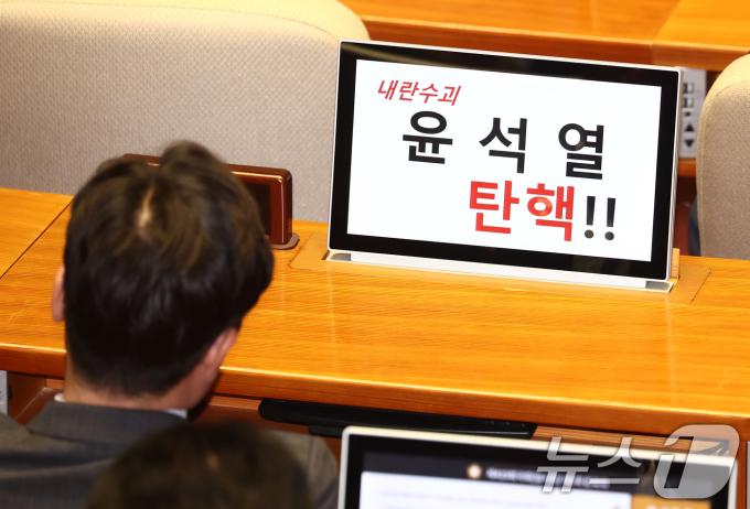13일 오후 서울 여의도 국회에서 열린 윤석열 대통령 위헌적 비상계엄 선포 내란행위 관련 본회의에 야당 의원들이 윤석열 대통령 탄핵을 촉구하는 문장을 모니터 화면에 띄워놓고 있다. 2024.12.13/뉴스1 ⓒ News1 김민지 기자