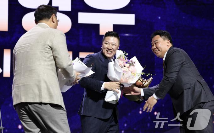 KIA 타이거즈 최형우가 13일 서울 강남구 코엑스 오디토리움에서 열린 ‘2024 신한은행 SOL KBO 골든글러브 시상식’에서 지명타자 부문 골든글러브를 수상한 후 심재학 단장, 이범호 감독에게 꽃다발을 받고 있다. 2024.12.13/뉴스1 ⓒ News1 김성진 기자