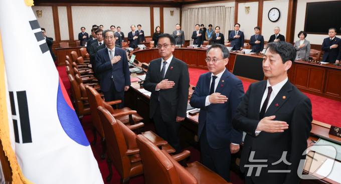 한덕수 대통령 권한대행 겸 국무총리가 14일 서울 종로구 정부서울청사에서 열린 임시 국무회의에서 국무위원들과 함께 국민의례를 하고 있다. 탄핵안 가결로 윤석열 대통령의 직무는 정지되고, 헌법에 따라 