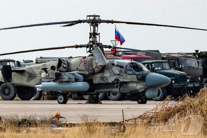 러시아 카모프 Ka-52 공격 헬기가 12일(현지시간) 시리아 북동부 카미실리 공항에 있는 러시아 공군 기지에 트럭, 차량들과 주둔하고 있다. 2024.12.13. ⓒ AFP=뉴스1 ⓒ News1 우동명 기자