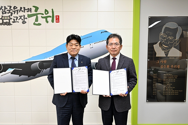 김진열 군위군수(오른쪽)와 임승환 영남사이버대 총장(왼쪽)이 업무협약서를 들어보이고 있다./사진제공=대구 군위군