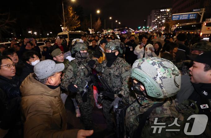 4일 새벽 서울 여의도 국회 앞에서 시민들이 경내로 진입하려는 계엄군을 붙잡아 막아서고 있다. 2024.12.4/뉴스1 ⓒ News1 구윤성 기자