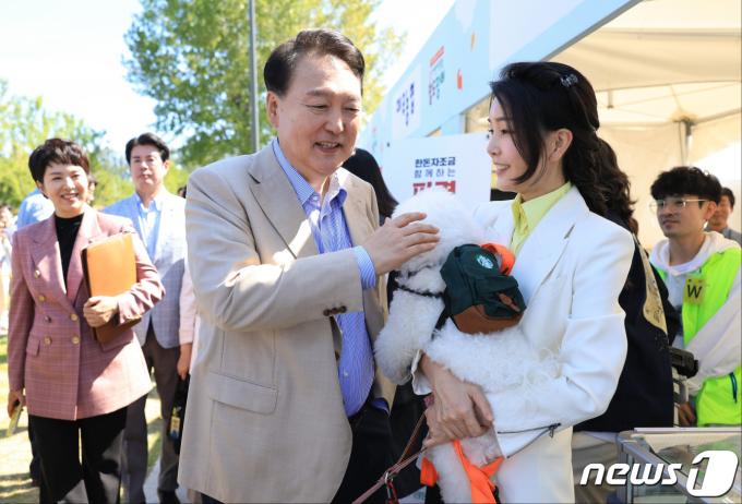 윤석열 대통령과 김건희 여사가 2023년 9월 24일 서울 용산어린이정원에서 열린 추석맞이 팔도장터를 깜짝 방문해 반려견 써니를 쓰다듬으며 대화하고 있다. (대통령실 제공) 2023.9.24/뉴스1 ⓒ News1 오대일 기자