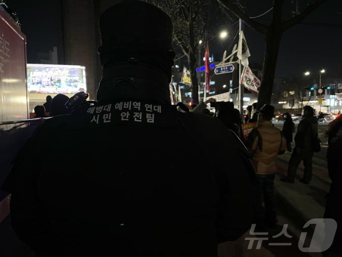 김 모 씨(남·42)가 '해병대예비역연대 시민안전팀'이라고 쓰인 조끼를 입고 집회 현장을 바라보고 있다. 2024.12.19 ⓒ 뉴스1 유수연 기자