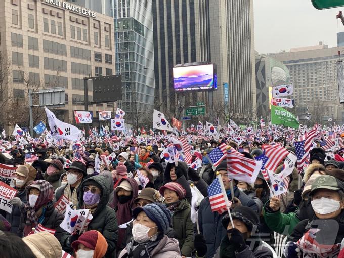 21일 오후 서울 종로구 동화면세점 앞에서 보수단체 자유통일당이 대통령 탄핵 반대 집회를 열고 있다. / 뉴스1 김종훈 기자